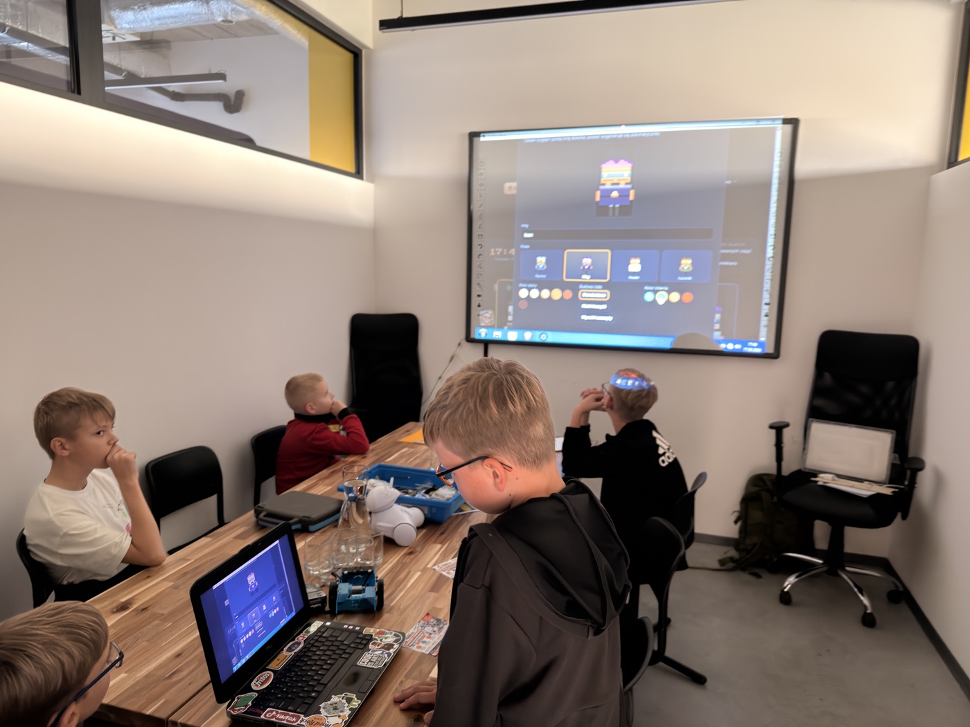 Uczestnicy warsztatów FireByte programują roboty na laptopach